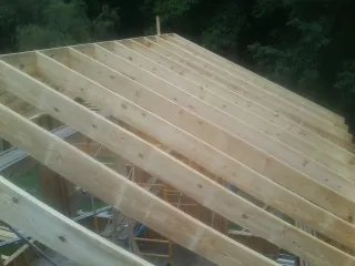 New roof rafters set over an addition before sheathing in Marion